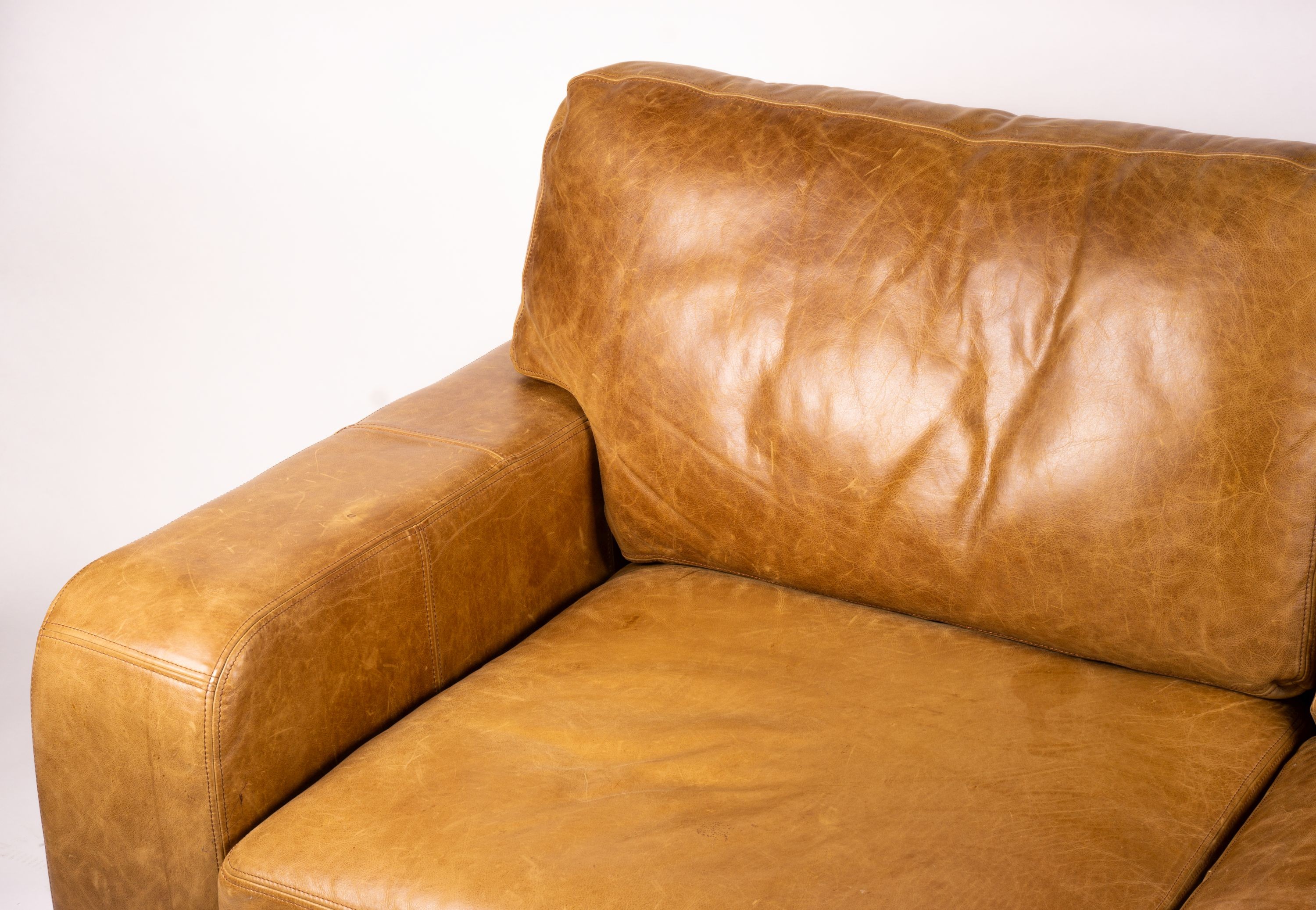 A pair of contemporary tan leather settees, length 200cm, depth 100cm, height 94cm